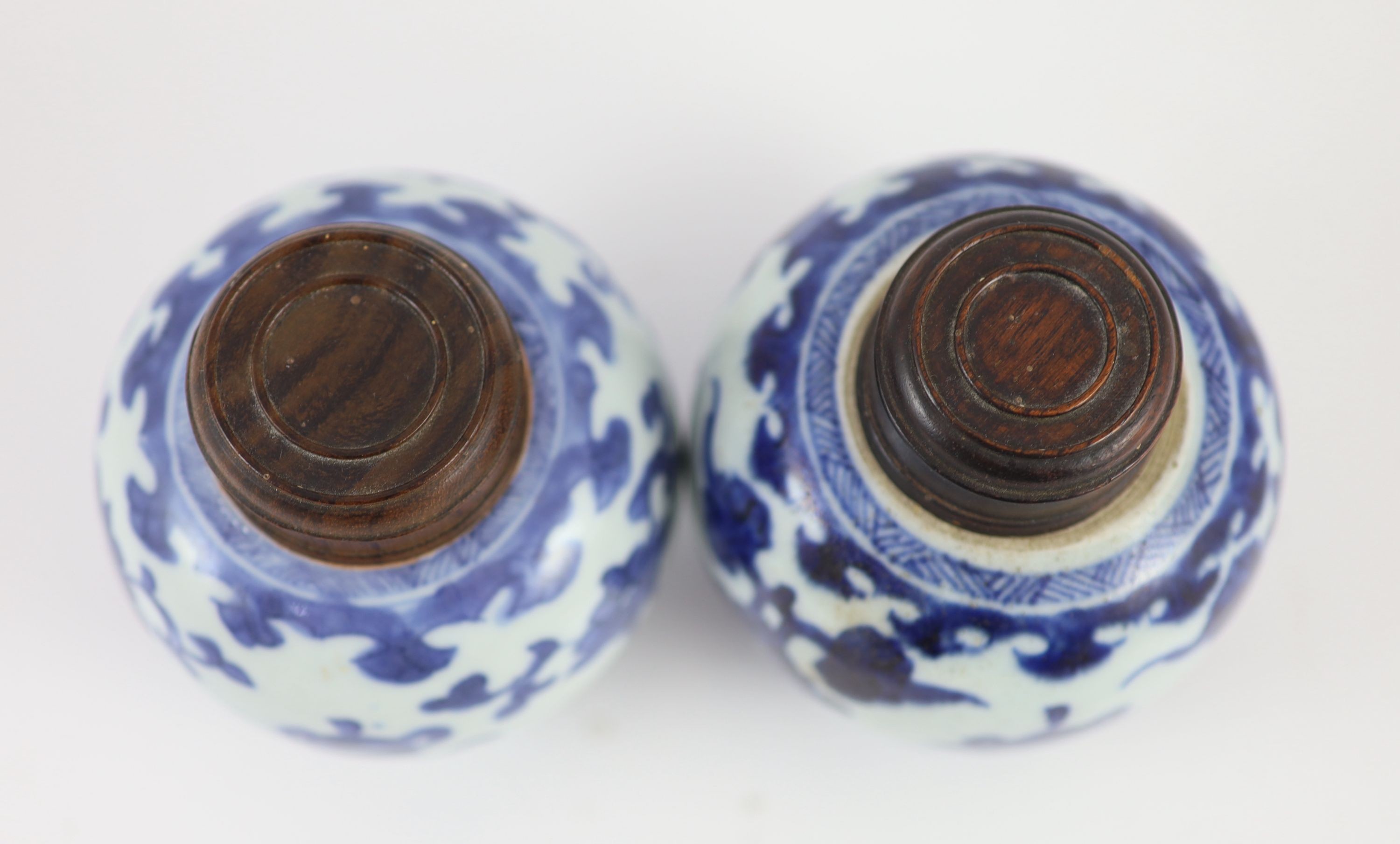 A near pair of Chinese blue and white ovoid jars, Kangxi period, 10 cm high, wood covers
